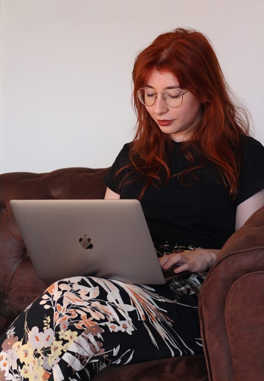 Celia Yélamos – bilingual creative copywriter working on a laptop, services extension section photo