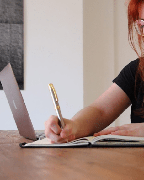 Celia Yélamos, bilingual copywriter, writing notes while working on a laptop – creative copywriting process